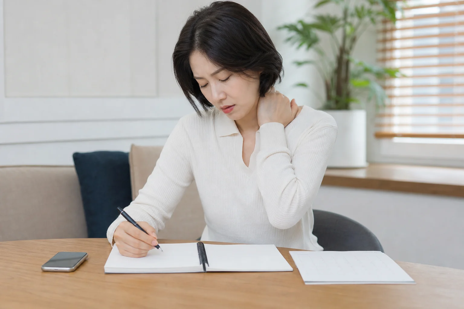 목디스크 환자가 목과 팔 저림, 수면 자세와 작업 후 악화 기록을 적는 장면
