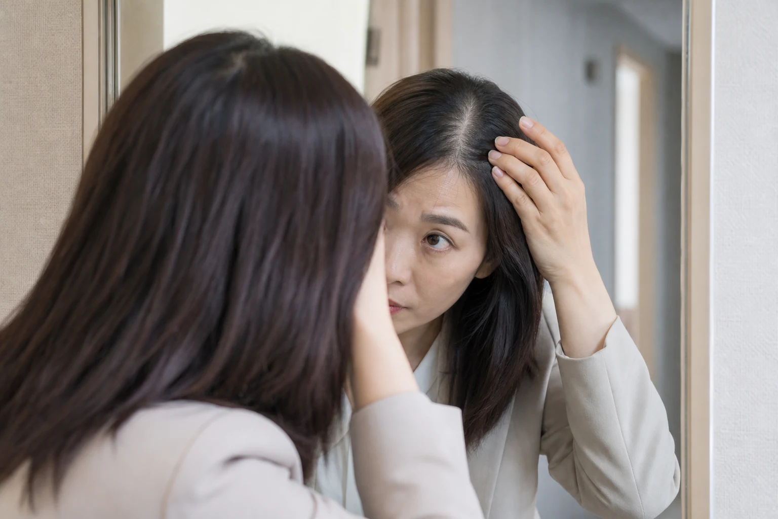 외출 준비 중 거울 앞에서 가르마의 변화를 보고 잠시 멈춘 여성형 탈모 환자