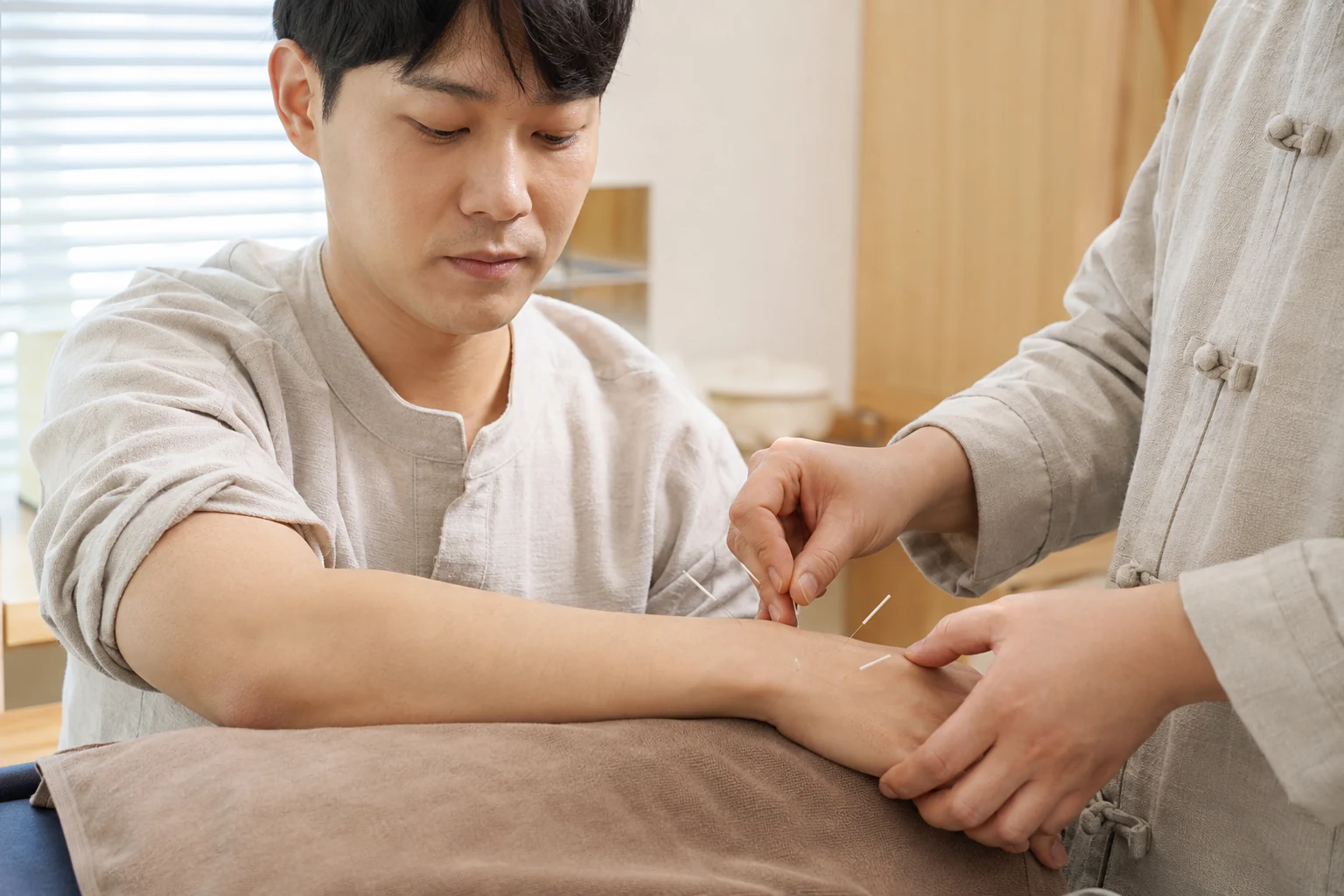 손과 전완에 침을 적용하는 장면을 표현한 이미지